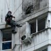 A specialist inspects the facade of a multi-storey Moscow apartment block damaged in a reported drone attack