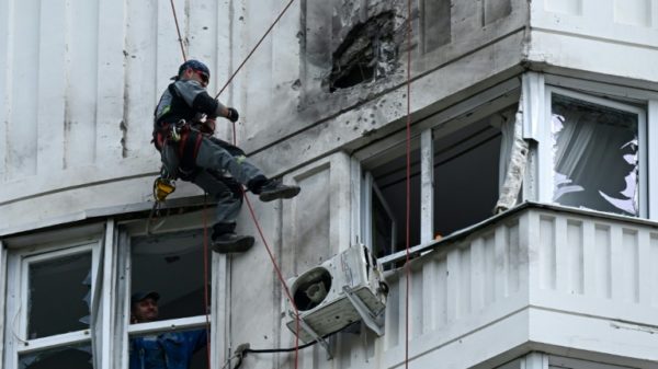 A specialist inspects the facade of a multi-storey Moscow apartment block damaged in a reported drone attack