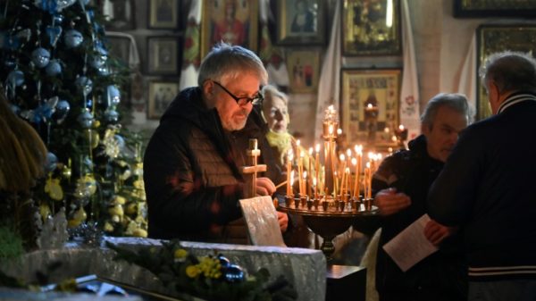 A man lights a candle during an Orthodox Christmas service at St John the Theologian Church in Kharkiv